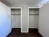 Modern apartment with dual closets, offering ample storage space and sleek wooden flooring.