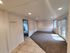 Bright living room with tile and carpet flooring, featuring French doors and recessed lighting.
