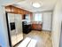 Bright and spacious kitchen with stainless steel appliances and elegant wooden cabinetry.