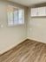 Inviting corner room with elegant hardwood floors and natural light from a window with blinds.