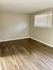Bright room with elegant hardwood flooring and natural light from a large window.