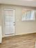 Inviting interior with a large window and door, featuring elegant blinds and wood flooring.