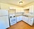 Bright and modern kitchen with white cabinets, sleek countertops, and essential appliances.