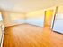 Bright living room with expansive hardwood floors and a modern refrigerator.
