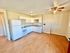 Bright kitchen with white cabinets, modern appliances, and wooden flooring.