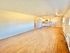 Spacious open-plan living area with wooden floors and a modern kitchen.