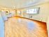 Bright apartment featuring an open living area with hardwood floors and a compact kitchen.