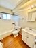 Bright bathroom featuring a modern vanity, bathtub, and natural light.