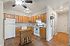 Bright, modern kitchen with wooden cabinets, white appliances, and an island counter.