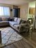 Inviting living room with a plush L-shaped sofa, warm lighting, and adjoining kitchen area.