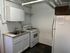Compact kitchen with sleek cabinetry, a stainless steel sink, modern stove, and a spacious refrigerator.