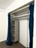 Elegant closet space with efficient shelving and deep blue curtains.