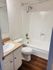 Bright and modern bathroom with sleek white fixtures and wood-style flooring.