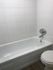 Elegant white bathroom with a modern bathtub and sleek fixtures.