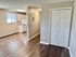 Inviting kitchen with warm lighting, sleek white cabinetry, and wood flooring.