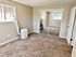 Inviting bedroom with carpet flooring, mirrored closet doors, and portable air conditioner.
