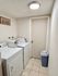 Bright laundry room featuring a washer, dryer, and framed artwork.