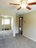 Bright and spacious bedroom with plush carpet, mirrored closet doors, and a ceiling fan.