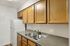 Charming kitchen featuring wooden cabinets, a double sink, and a pristine white refrigerator.