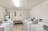 Bright and organized laundry room featuring multiple washing machines and ample space for laundry tasks.