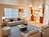Elegant open living room with plush seating, stylish decor, and modern kitchen features.