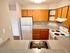 Charming kitchen with wooden cabinets, electric stove, and sleek countertops.