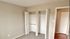 A bright and spacious bedroom featuring dual closets and a soft carpeted floor.