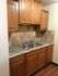 Elegant kitchen area with granite countertops, wooden cabinets, and double sink setup.