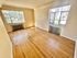 Bright and airy room with wooden flooring and large windows offering views of nature.