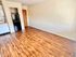 Bright kitchen area with modern appliances and wooden flooring, perfect for small apartment living.