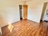Bright and inviting bedroom with wooden floors and natural light streaming through the window.