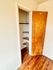 Inviting closet space with wooden shelves and a wooden door, perfect for organization.