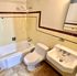 Charming bathroom with vintage tiles, bathtub, white sink, and toilet.