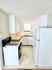 Efficient kitchen layout with modern appliances, featuring ample cabinetry and tiled backsplash.