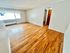 Inviting room with polished hardwood floors and ample natural light from a large window.