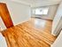 Bright room with polished hardwood floors and large window for natural light.