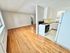 Inviting open-plan living area featuring hardwood floors and an adjoining kitchen with modern appliances.