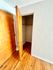 Cozy wooden-floored closet with an open door in a modern apartment.