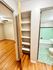 Inviting apartment hallway displaying built-in shelving, hardwood floors, and a glimpse of a tiled bathroom.