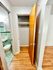 Inviting space showcasing a wooden closet door, hardwood flooring, and a glimpse of a mint tile bathroom.