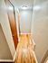 Bright hallway with wooden doors and polished hardwood flooring, illuminated by a modern ceiling light.