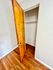 Inviting closet space in a modern room with polished wooden floors and an open door.