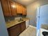 Contemporary kitchen with granite countertops, brown cabinets, and modern appliances.
