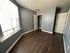 Bright and airy bedroom with large window, modern wood flooring, and spacious closet.