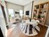 Bright modern living room with cozy seating, chic decor, and a stylish bookshelf, perfect for relaxation.