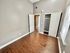 Bright room with wood flooring, a closet with sliding doors, and a white wall accent.