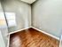 Bright and airy bedroom with polished hardwood flooring and ample natural light.