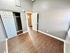 Inviting bedroom with elegant wood flooring, modern gray walls, and a functional closet space.