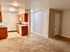 Contemporary kitchen with wood cabinetry, granite countertops, and bright overhead lighting.