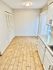 Contemporary kitchen with light wood flooring, sleek countertops, and ample cabinetry.